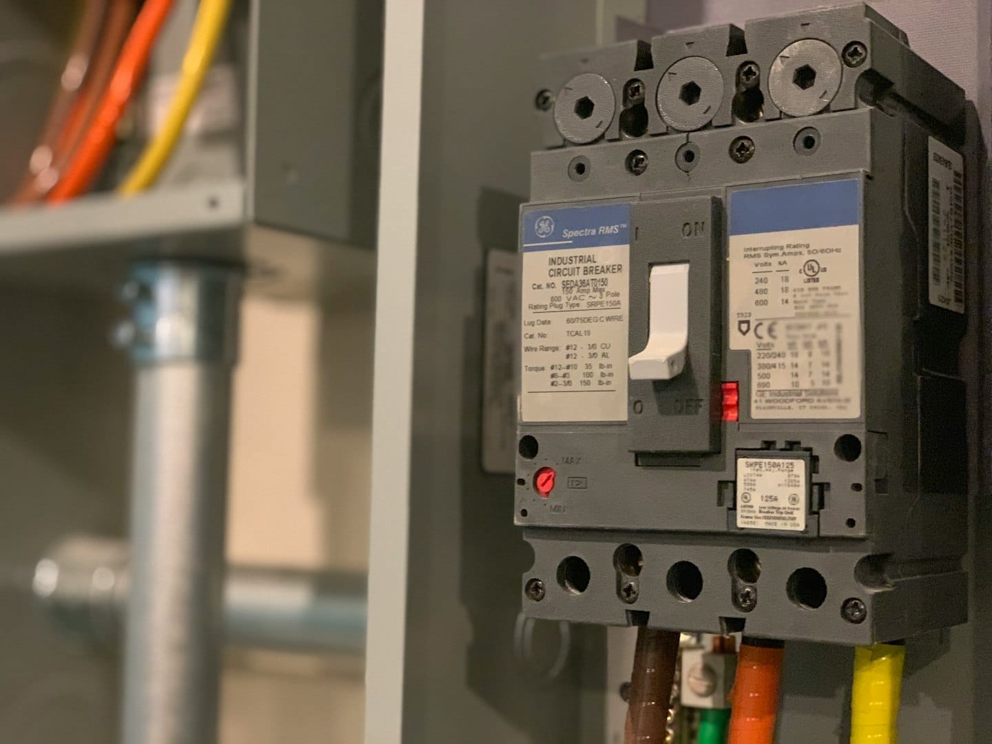 Industrial circuit breaker with colorful wires in an electrical panel.