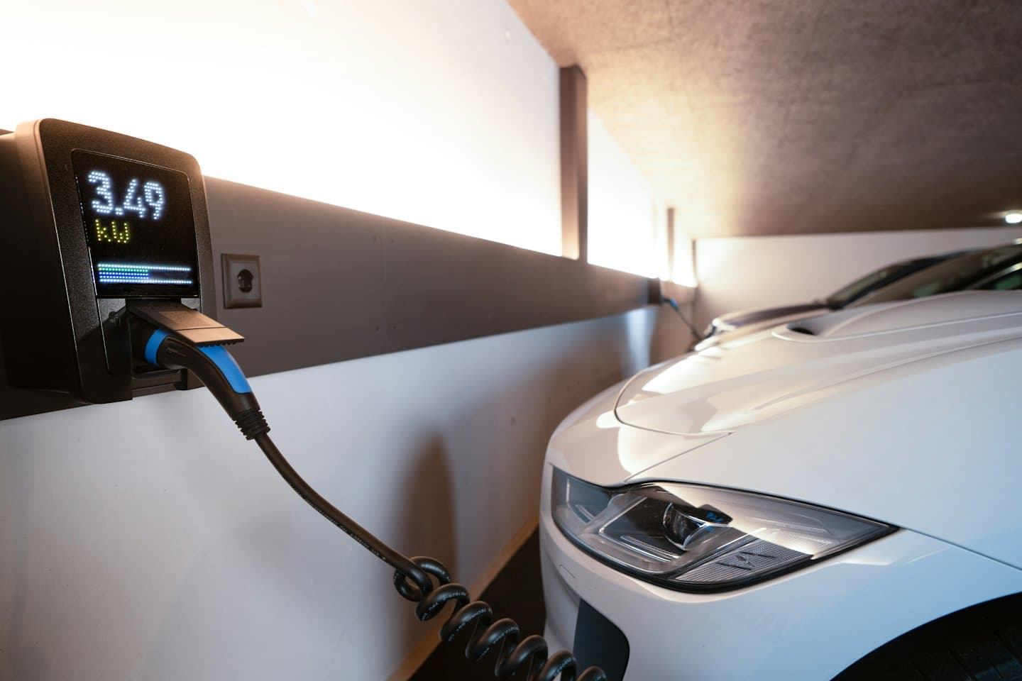 White electric car charging in a modern home garage.