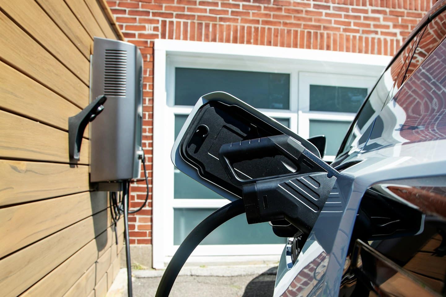 Electric car charging cable plugged into a grey vehicle.