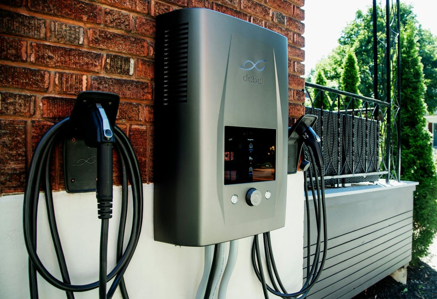 Electric vehicle charging station mounted on a red brick house.