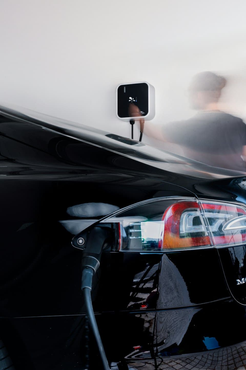 Glossy electric car charging in a modern garage.